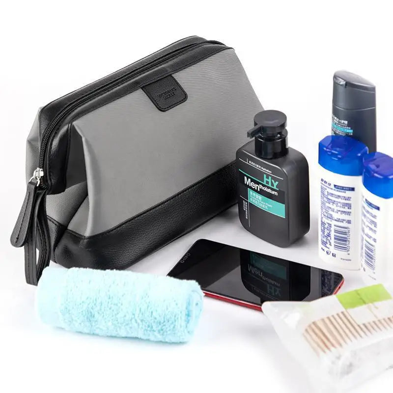Grooming kit with a gray toiletry bag, bottles, a phone, and a towel on a white background