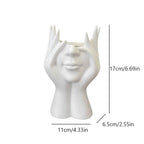White ceramic vase shaped like a face with measurements on a white background