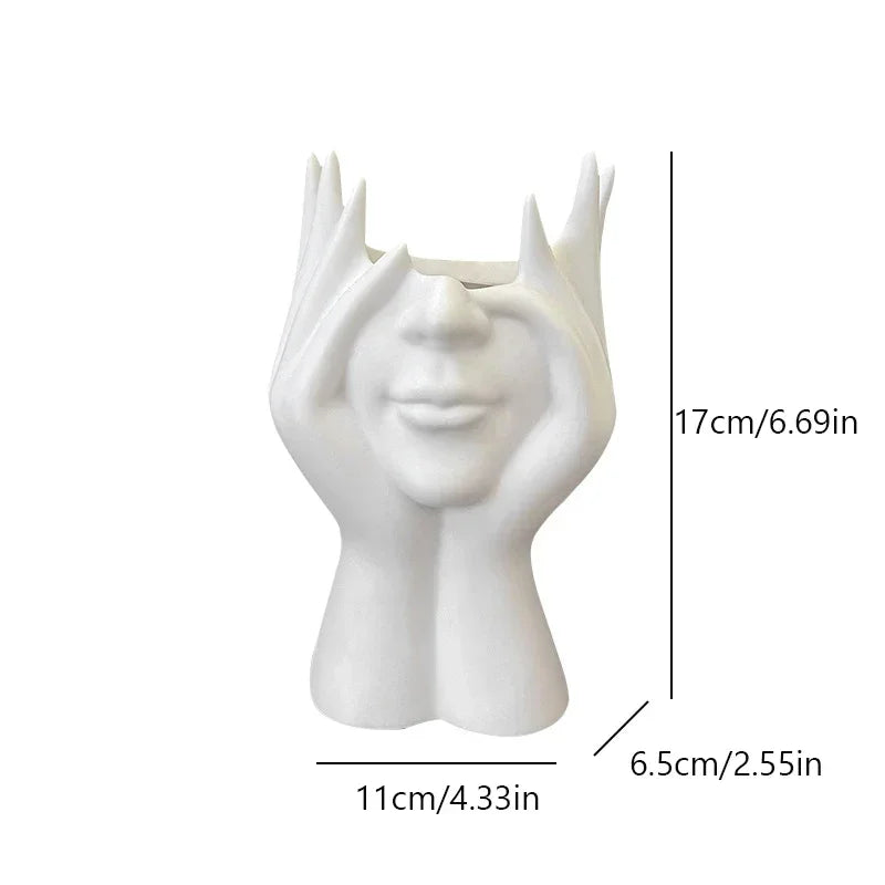 White ceramic vase shaped like a face with measurements on a white background