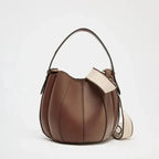 Brown leather handbag with a beige strap on a white background