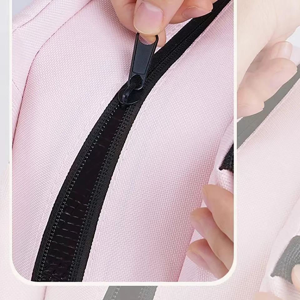 Close-up of a pink garment with a black zipper being pulled by a hand.
