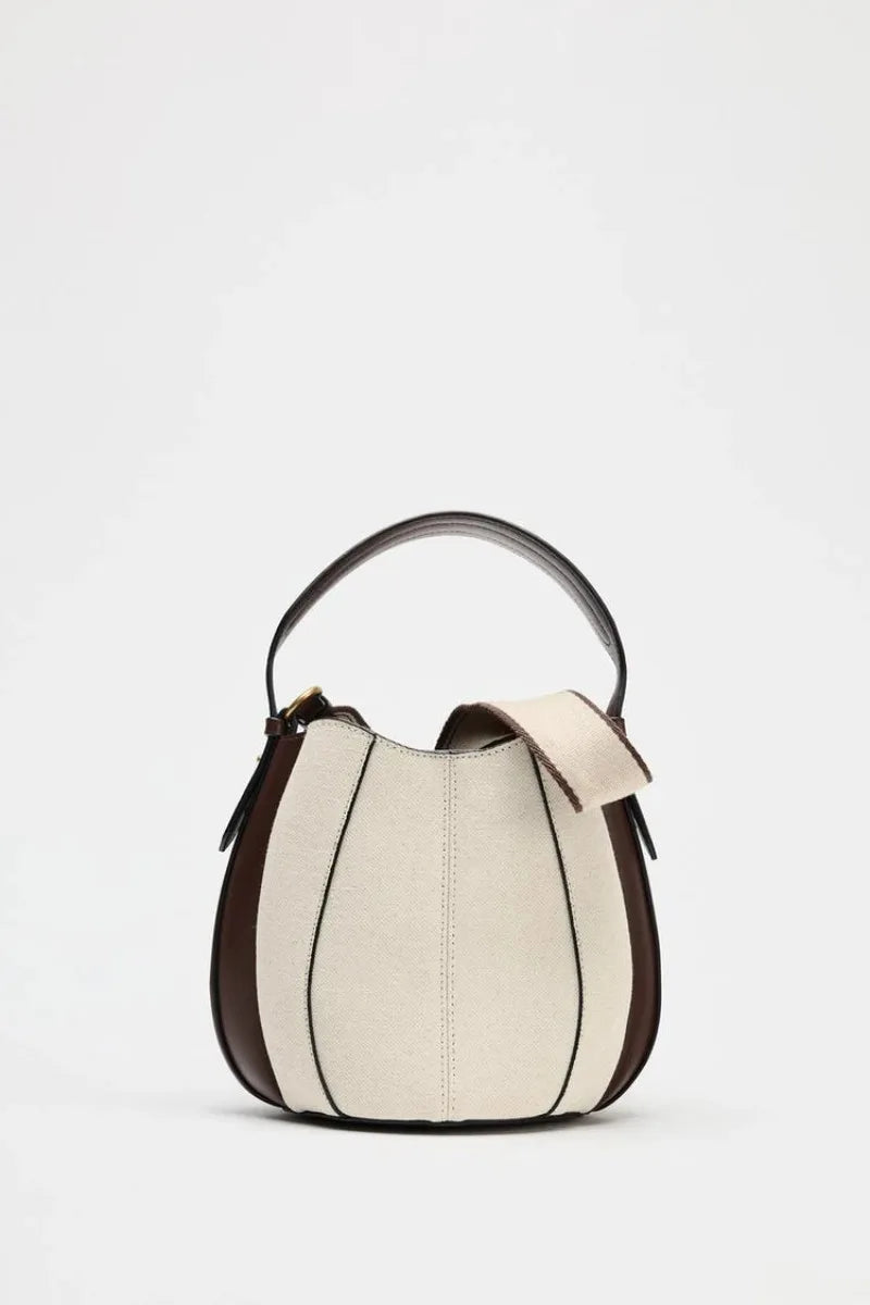 Two-tone handbag with black and beige design on a white background