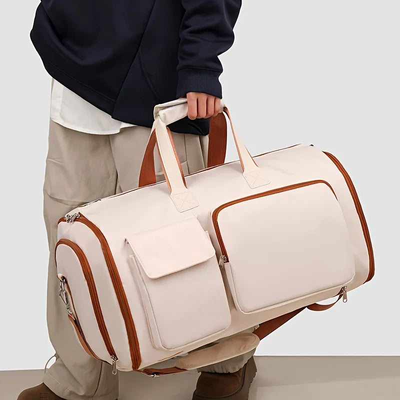 Person holding a beige duffel bag with brown accents on a light gray background